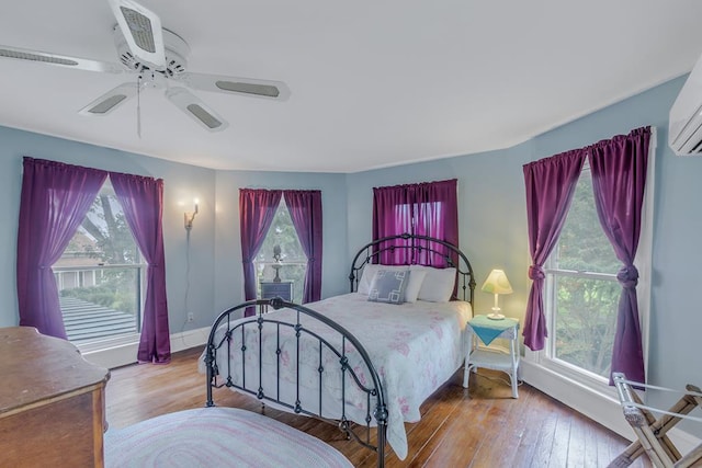 bedroom featuring a ceiling fan, baseboards, and wood finished floors