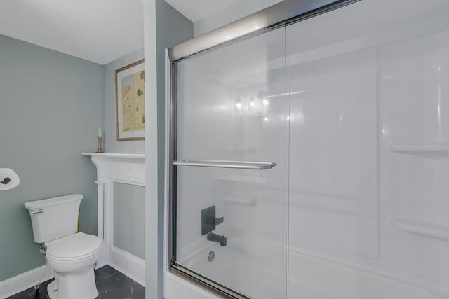 bathroom featuring bath / shower combo with glass door, toilet, and baseboards