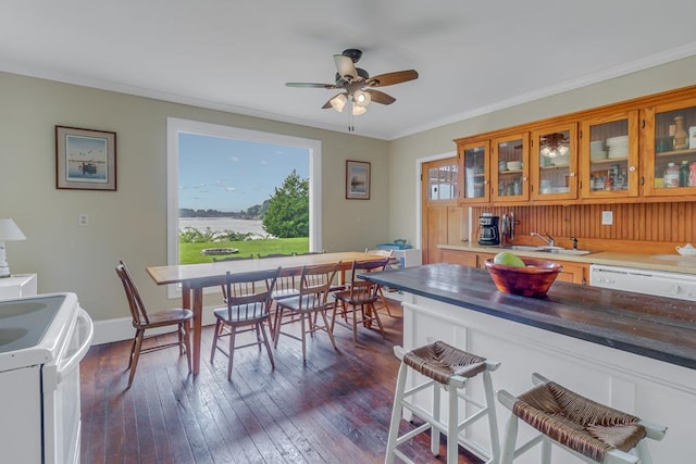 dining area with ornamental molding, dark wood finished floors, a ceiling fan, and baseboards