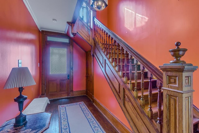 foyer entrance with ornamental molding, stairway, and hardwood / wood-style floors