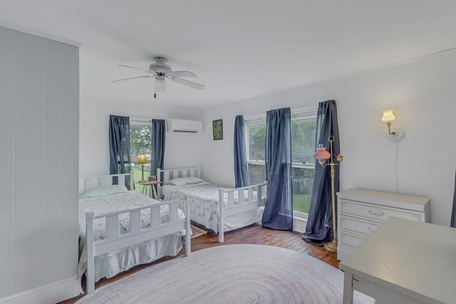 bedroom featuring ceiling fan, wood finished floors, and a wall mounted AC