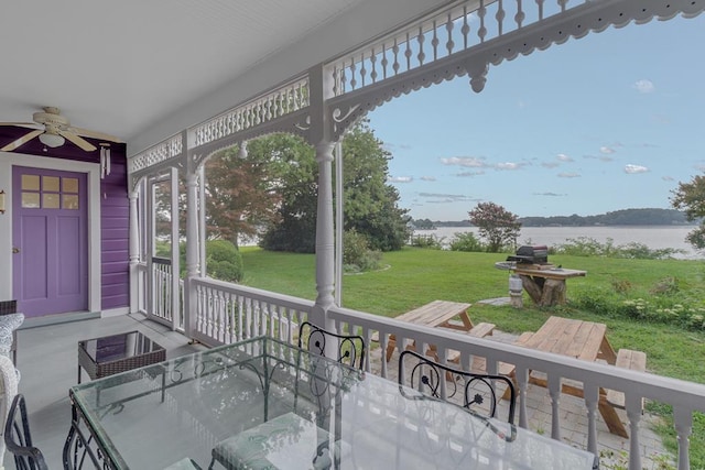 exterior space with a ceiling fan and a water view