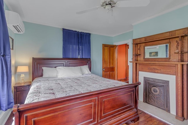 bedroom with a ceiling fan, ornamental molding, an AC wall unit, and wood finished floors