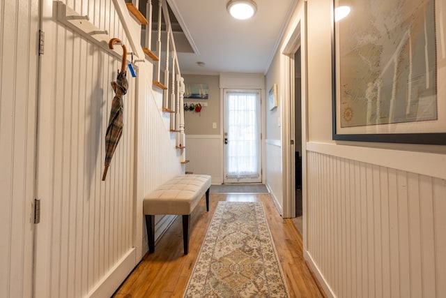 doorway featuring crown molding and light hardwood / wood-style floors