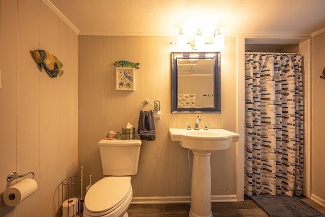 bathroom with hardwood / wood-style floors, toilet, ornamental molding, and wood walls