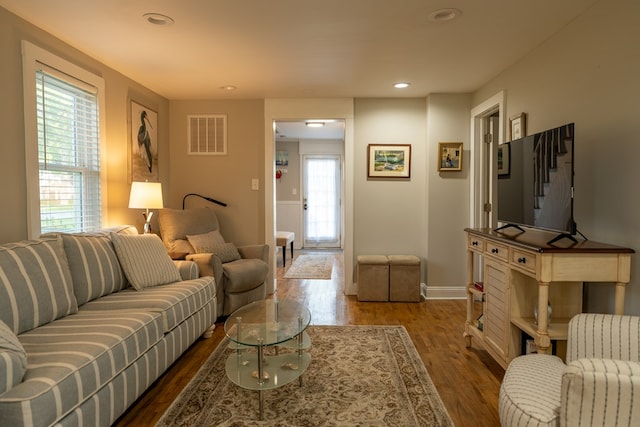 living room with a wealth of natural light and dark hardwood / wood-style flooring