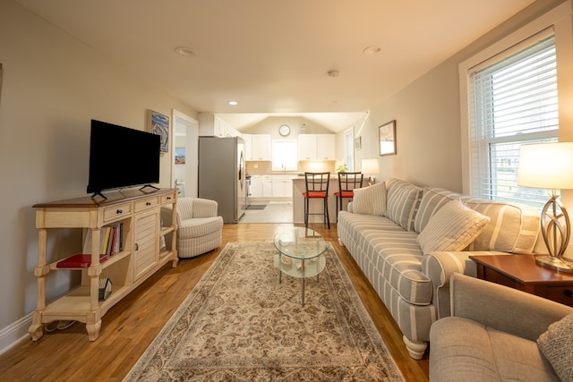 living room with light hardwood / wood-style flooring and lofted ceiling