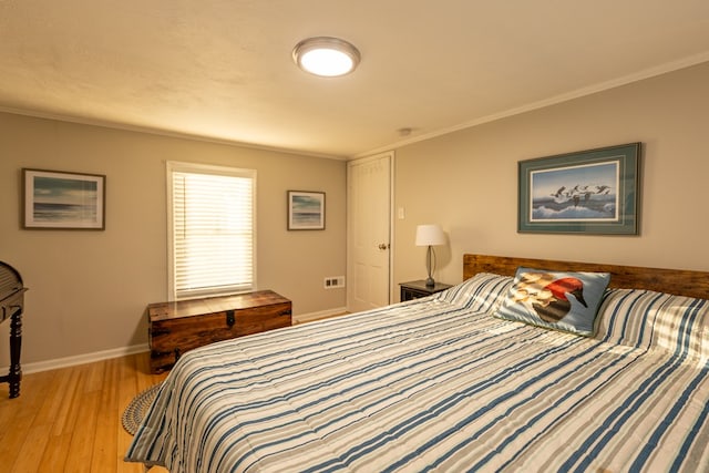 bedroom with light hardwood / wood-style flooring and ornamental molding