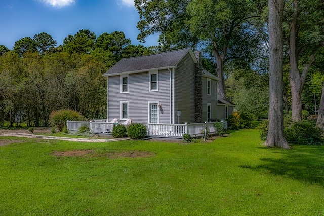 rear view of property featuring a yard and a wooden deck