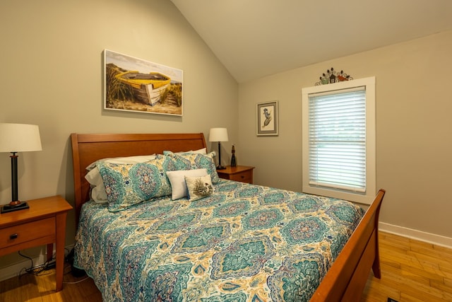 bedroom featuring hardwood / wood-style floors and vaulted ceiling