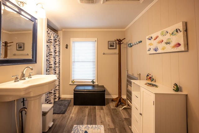 bathroom featuring wood-type flooring, toilet, and crown molding