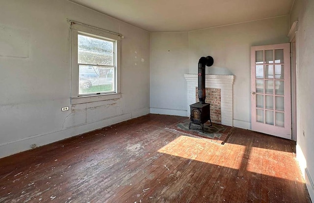 unfurnished living room featuring a wood stove and dark hardwood / wood-style floors