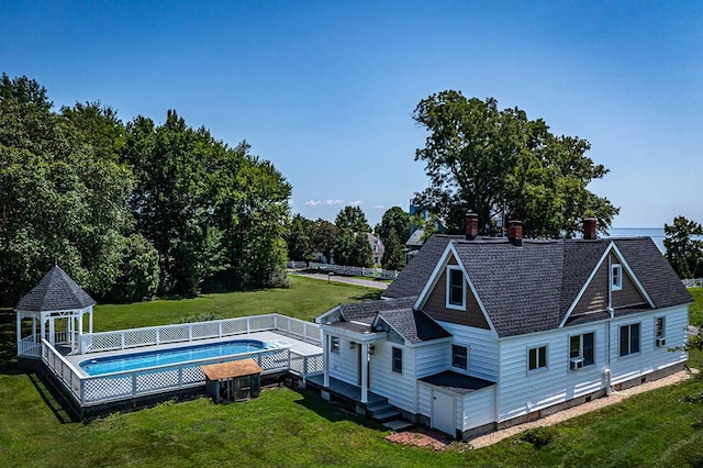 rear view of property featuring a gazebo and a yard