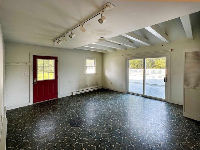 empty room with rail lighting and a baseboard heating unit