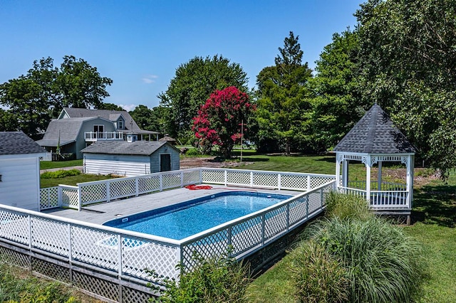 view of pool with a gazebo, a yard, and an outdoor structure