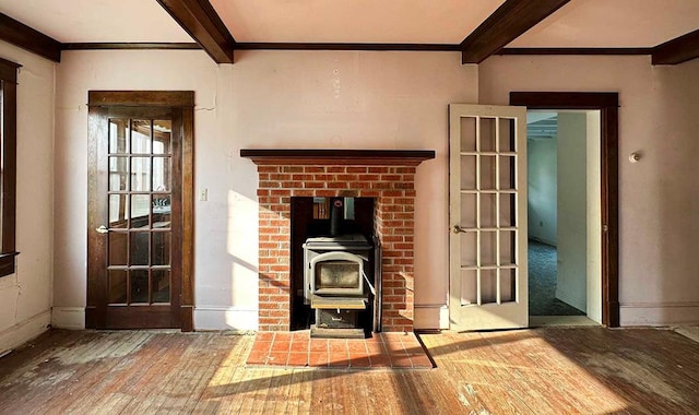 unfurnished living room with beamed ceiling, a wood stove, and french doors