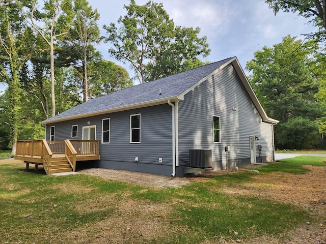 rear view of property with a wooden deck, a yard, and central AC unit