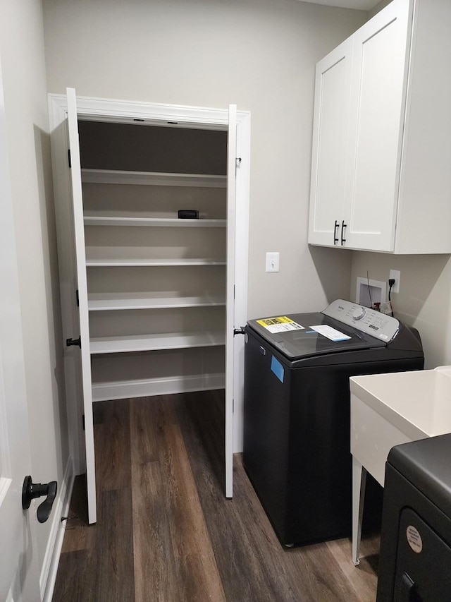 laundry area featuring washer and clothes dryer, sink, cabinets, and dark hardwood / wood-style floors