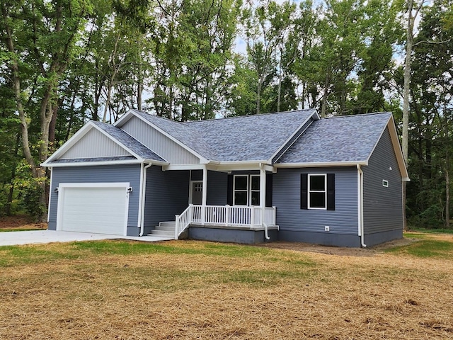 view of front facade featuring covered porch, a garage, and a front yard