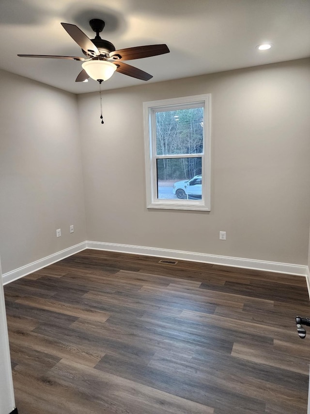 empty room with ceiling fan and dark wood-type flooring