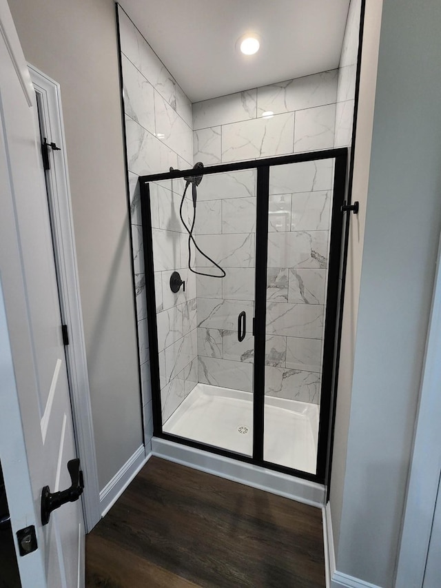 bathroom featuring wood-type flooring and a shower with door