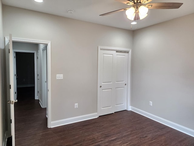 unfurnished bedroom featuring ceiling fan, dark hardwood / wood-style flooring, and a closet