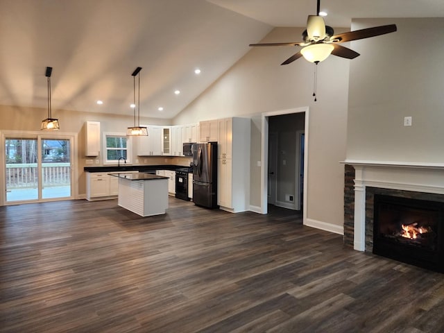 kitchen with white cabinets, sink, stainless steel refrigerator with ice dispenser, hanging light fixtures, and a kitchen island