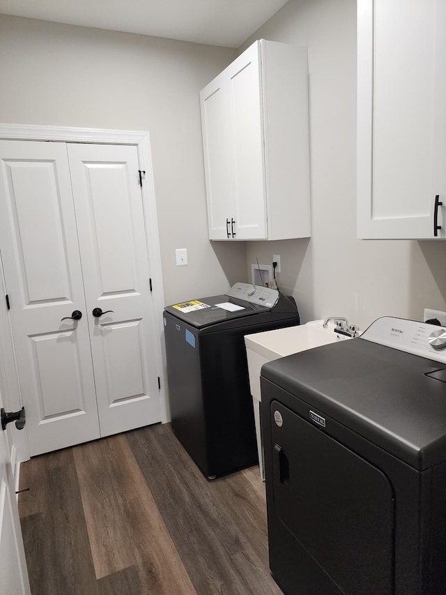 laundry room featuring washer and clothes dryer, dark hardwood / wood-style floors, and cabinets