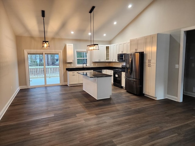 kitchen with decorative light fixtures, a center island, white cabinetry, and stainless steel appliances