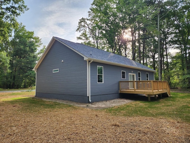 view of property exterior with a yard and a wooden deck