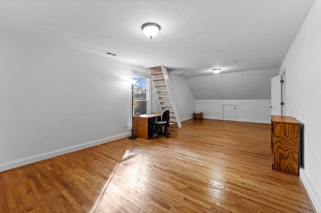 additional living space featuring lofted ceiling and hardwood / wood-style flooring