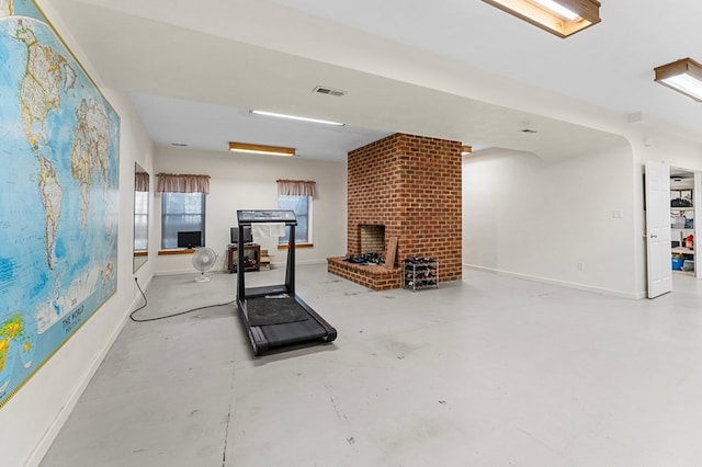 exercise area with a brick fireplace