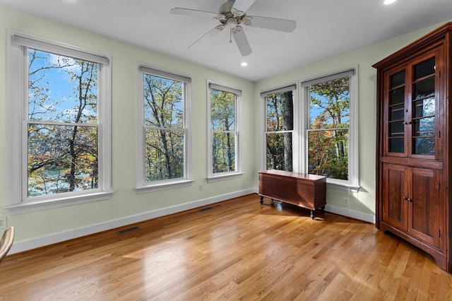 unfurnished sunroom with ceiling fan and plenty of natural light