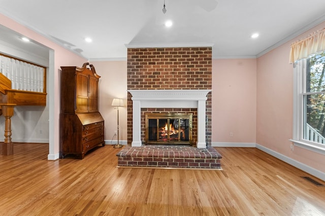 unfurnished living room featuring a fireplace, light hardwood / wood-style flooring, and ornamental molding