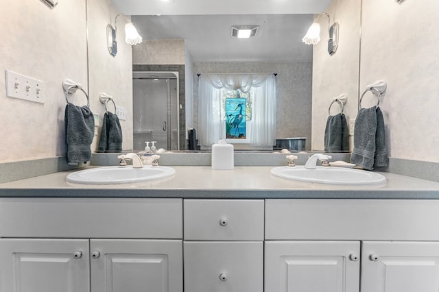 bathroom featuring a shower with door and vanity