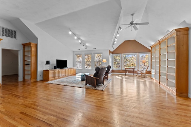 living room with ceiling fan, vaulted ceiling, and light hardwood / wood-style flooring