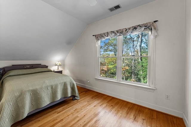 bedroom featuring hardwood / wood-style floors and lofted ceiling