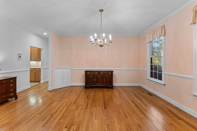 unfurnished dining area featuring light hardwood / wood-style flooring, a chandelier, and ornamental molding