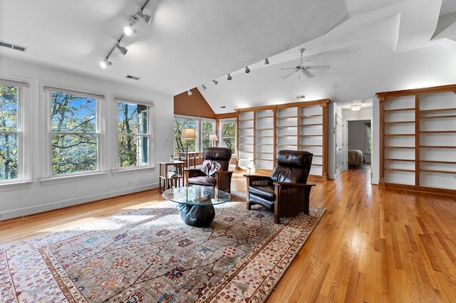 living room featuring ceiling fan, light wood-type flooring, and lofted ceiling