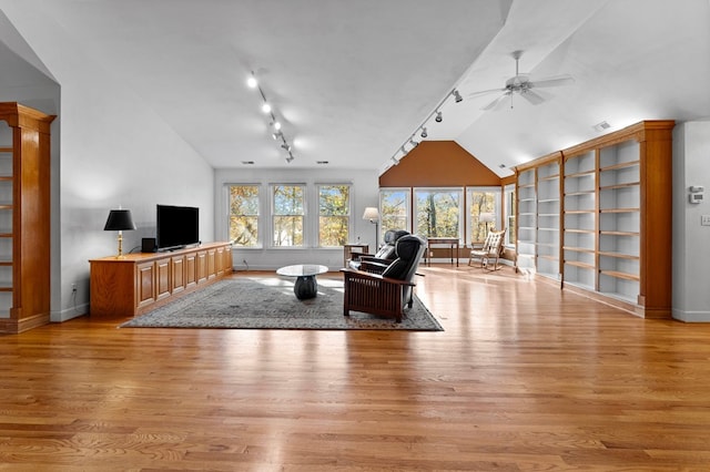 living room featuring ceiling fan, lofted ceiling, and light hardwood / wood-style flooring