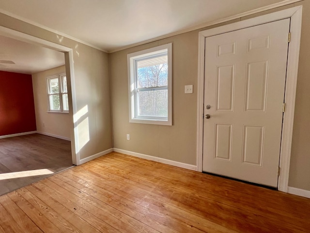 entrance foyer with light hardwood / wood-style floors and crown molding