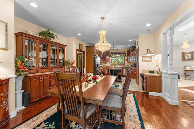 309 Nomini Bay Dr, Montross, VA 22520 - dining area with light wood-style flooring, a chandelier, recessed lighting, and ornate columns