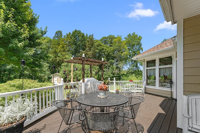 309 Nomini Bay Dr, Montross, VA 22520 - wooden terrace featuring a pergola, outdoor dining space, a storage shed, and view of wooded area