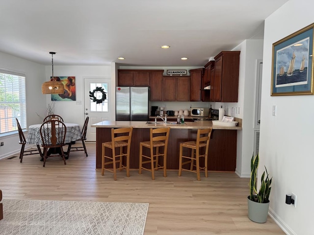 230 Roseneath Ave, Kilmarnock, VA 22482 - kitchen featuring freestanding refrigerator, a peninsula, light wood-type flooring, baseboards, and recessed lighting