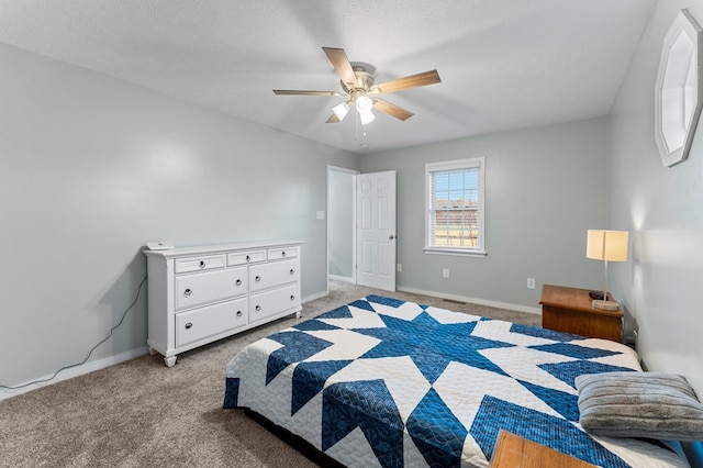 bedroom featuring ceiling fan, light colored carpet, and a textured ceiling