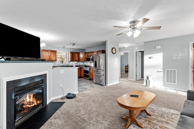 carpeted living room with ceiling fan and a textured ceiling