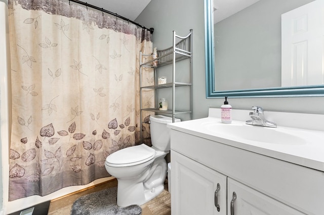 bathroom with curtained shower, vanity, and toilet