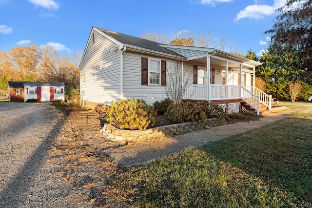 view of home's exterior featuring a yard, an outbuilding, and covered porch