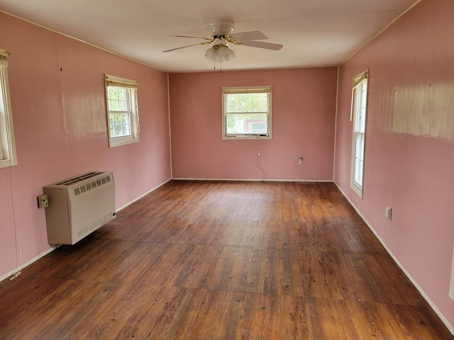 unfurnished room with a wealth of natural light, hardwood / wood-style floors, and a ceiling fan
