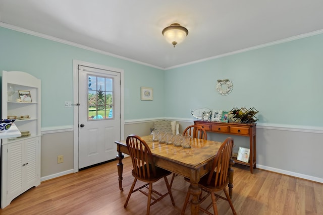 dining room with ornamental molding and light wood-type flooring